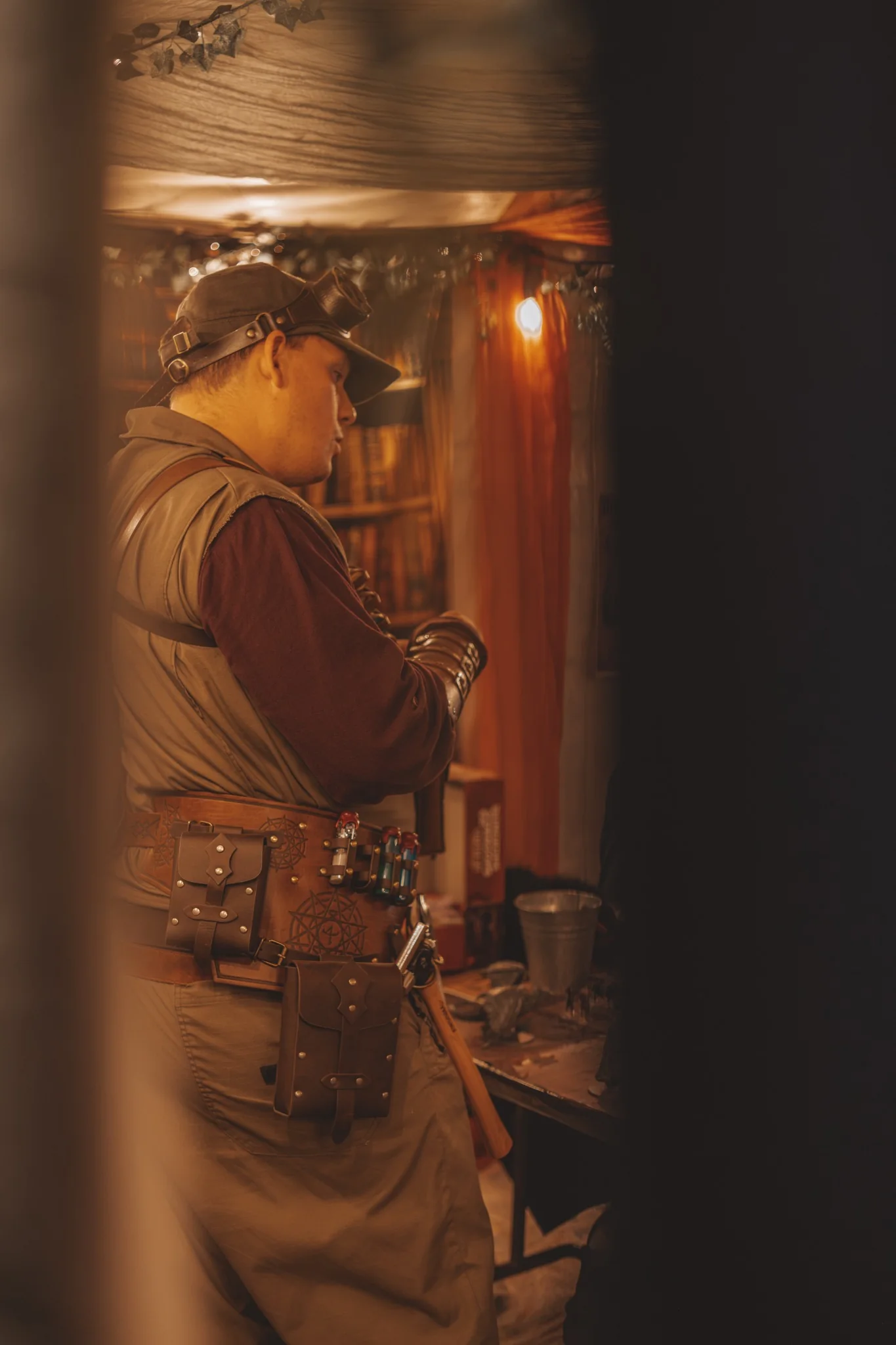 A costumed facilitator standing inside the warmly lit Valley of the Nerds tent.