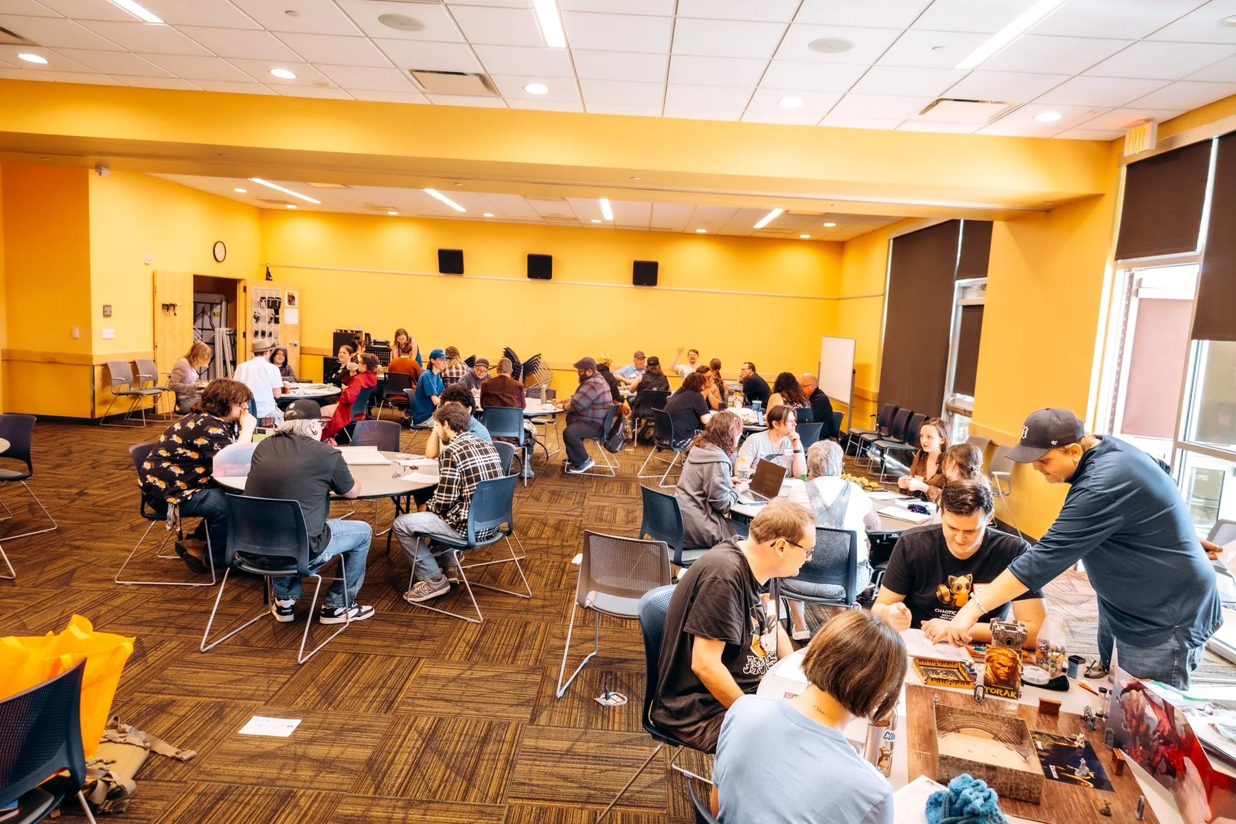 A wide shot of multiple tables of players during a Valley of the Nerds game event.
